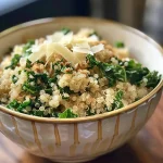 ['A close-up view of a creamy cheesy quinoa bowl with kale and toppings.', 'A vibrant quinoa bowl featuring a creamy cheese sauce and fresh greens.', 'A side view of a delicious quinoa dish showcasing its creamy texture and colorful ingredients.', 'A rich quinoa bowl filled with cheese, spices, and chopped kale, captured with an iPhone.']