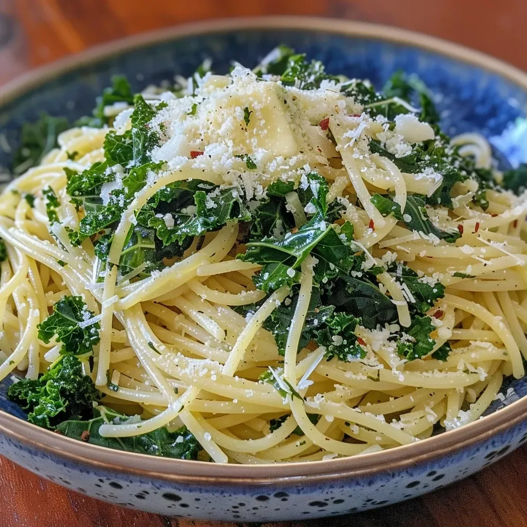 Close-up side view of a bowl of Garlic Parmesan Kale Pasta with vibrant green kale and golden pasta.