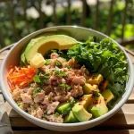 ['Close-up view of a protein-packed tuna bowl featuring vibrant ingredients.', 'A colorful, healthy tuna bowl with avocado, quinoa, and greens.', 'Side view of a delicious tuna bowl with fresh vegetables and a lemon wedge.', 'Juicy protein tuna bowl with a mix of greens, cucumbers, and shredded carrots.']