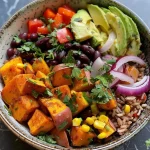['Close-up view of colorful Sweet Potato Bowls with diced sweet potatoes, black beans, and fresh avocado.', 'Vibrant Sweet Potato Bowls featuring layers of diced sweet potatoes, red bell pepper, and topped with cilantro.', 'Side view of a healthy Sweet Potato Bowl filled with roasted vegetables and garnished with fresh herbs.', 'Delicious Sweet Potato Bowls showcasing an array of ingredients including corn, zucchini, and black beans.']