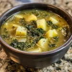 ['Close-up view of a bowl of Easy Kale Soup with visible kale leaves and diced potatoes.', 'Side angle of a steaming bowl of Easy Kale Soup, showcasing rich green kale and creamy broth.', 'Delicious Easy Kale Soup in a bowl, featuring chunks of potatoes and herbs, taken with an iPhone.', 'Close-up of a vibrant bowl of Easy Kale Soup, highlighting fresh ingredients like kale and garlic.']