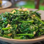 ['Fresh sautéed spinach with garlic and onions in a colorful dish.', 'Close-up of vibrant green sautéed spinach garnished with garlic pieces.', 'Sautéed spinach glistening with olive oil and sprinkled with red pepper flakes.', 'Plate of sautéed spinach with visible garlic and onions, ready to serve.']