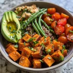 ['A close-up view of vibrant Sweet Potato Grain Bowls featuring cubed sweet potatoes, green beans, and cherry tomatoes.', 'Side view of a colorful grain bowl with sweet potatoes, quinoa, avocado slices, and garnished with parsley.', 'Juicy Sweet Potato Grain Bowl showcasing fresh ingredients like green beans and halved cherry tomatoes.', 'Detailed close-up of a healthy grain bowl composed of sweet potatoes, avocado, and a yellow turmeric honey mustard dressing.']