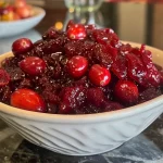 Close-up view of a bowl of air fryer cranberry sauce with visible cranberries and orange zest.
