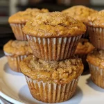 Close-up of golden brown pumpkin muffins with a dusting of cinnamon.