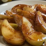 Close-up of caramelized cinnamon-spiced pears glistening on a plate.