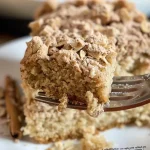 A side view of a fluffy gluten-free maple cake adorned with cream cheese frosting.
