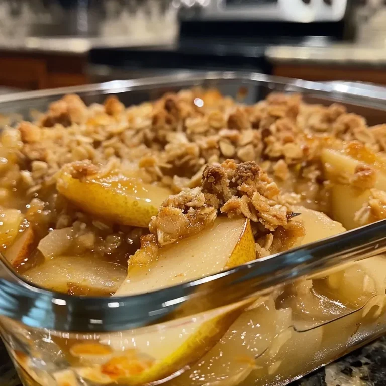 A close-up view of a baked pear crisp dessert, showcasing golden oats and sliced pears.